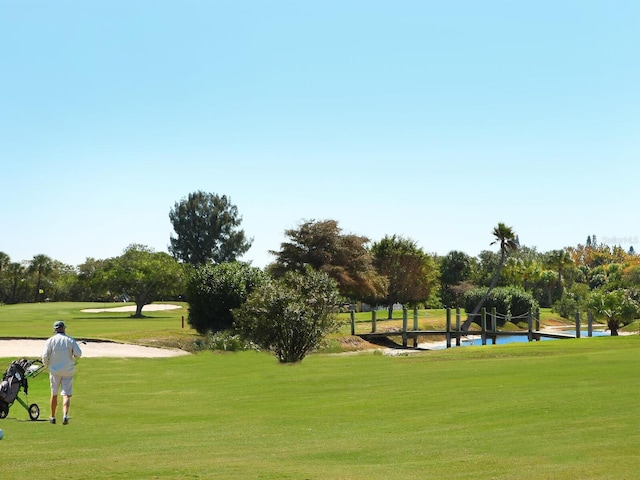 view of home's community with a water view and a lawn