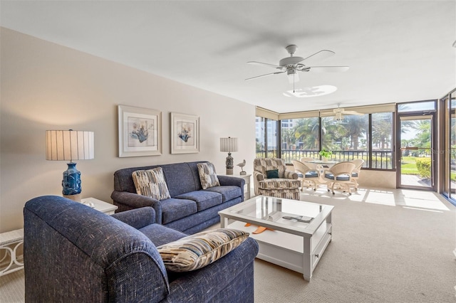 living room featuring ceiling fan, expansive windows, light colored carpet, and a wealth of natural light