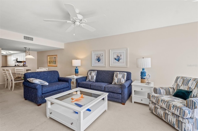 carpeted living room with ceiling fan