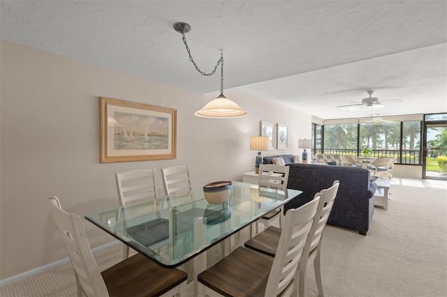 dining space with ceiling fan and light carpet