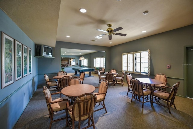 carpeted dining area with ceiling fan