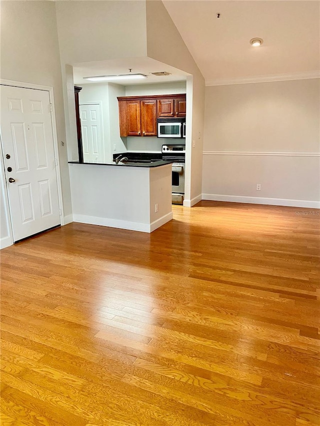 unfurnished living room with light hardwood / wood-style flooring, lofted ceiling, and ornamental molding