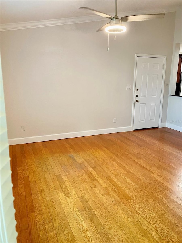 spare room with ceiling fan, light wood-type flooring, and crown molding