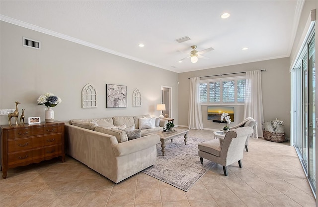 living room with a ceiling fan, visible vents, crown molding, and light tile patterned flooring