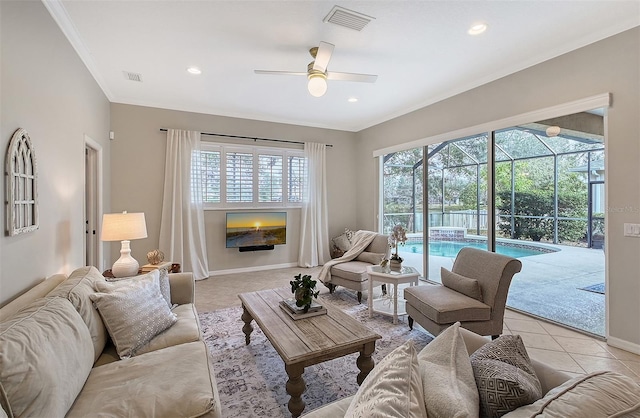 living area with light tile patterned floors, baseboards, visible vents, a sunroom, and ornamental molding