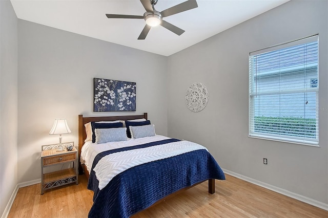 bedroom featuring ceiling fan, baseboards, and wood finished floors