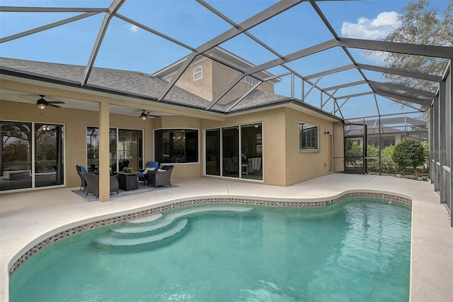 outdoor pool with glass enclosure, a ceiling fan, and a patio