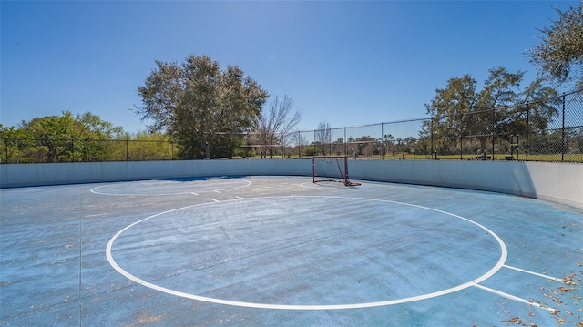 view of sport court featuring fence