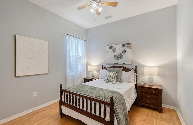 bedroom with light wood-type flooring, visible vents, and baseboards