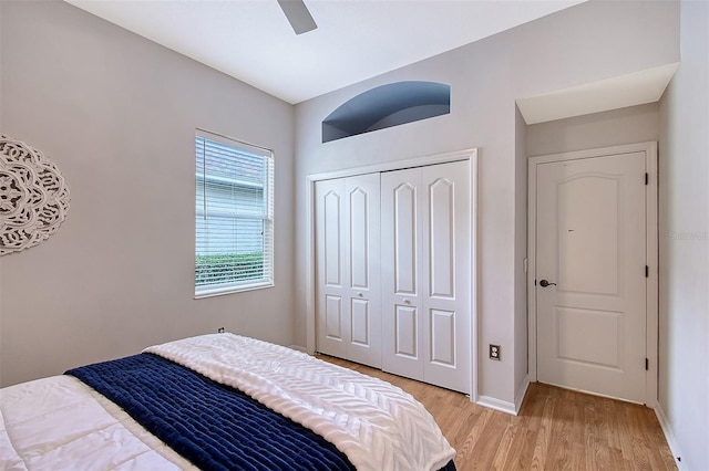 bedroom featuring light wood-type flooring, a closet, ceiling fan, and baseboards