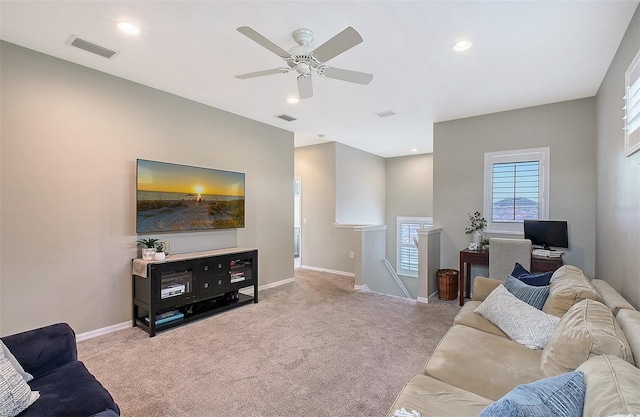 living room featuring baseboards, visible vents, and light colored carpet