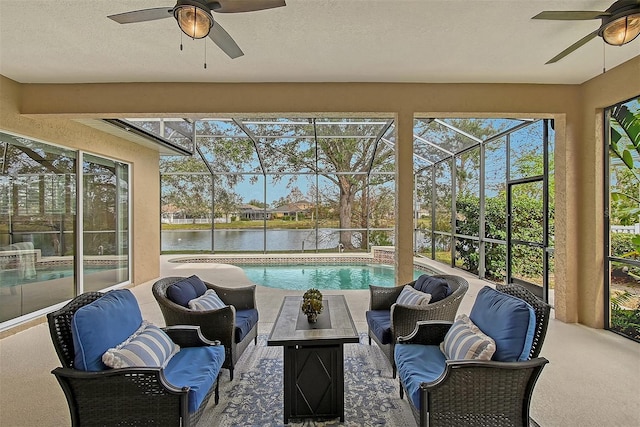 sunroom / solarium featuring a water view and ceiling fan