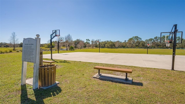 view of basketball court with community basketball court and a lawn