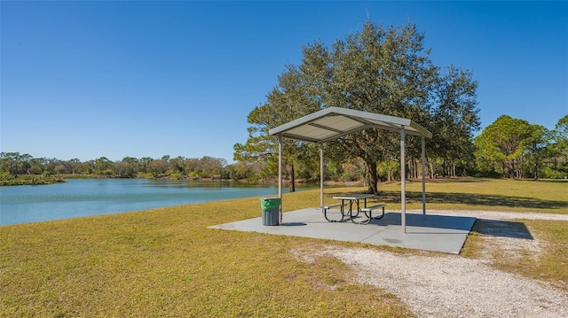 surrounding community featuring a water view and a lawn