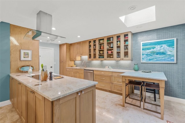 kitchen featuring a skylight, stainless steel dishwasher, light brown cabinetry, tasteful backsplash, and kitchen peninsula