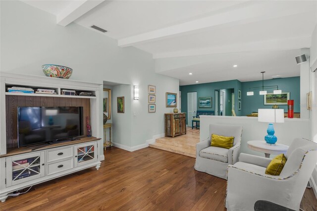 living room with hardwood / wood-style flooring and vaulted ceiling with beams