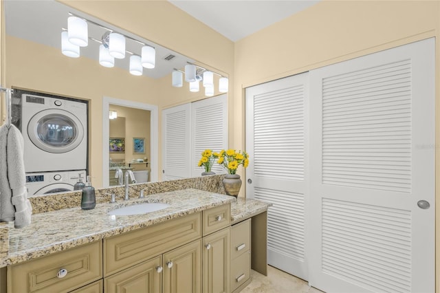 bathroom with vanity and stacked washer / drying machine