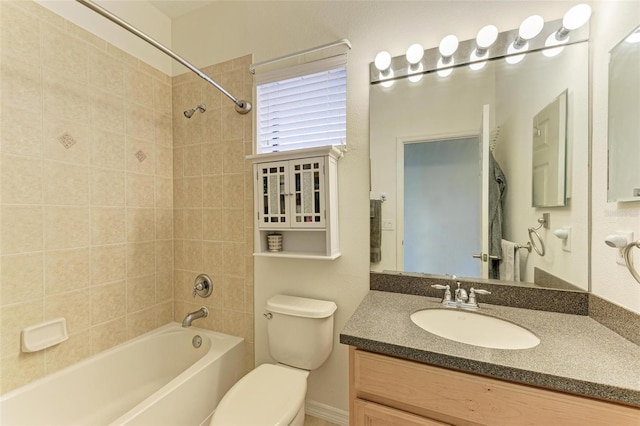 full bathroom featuring vanity, tiled shower / bath combo, and toilet