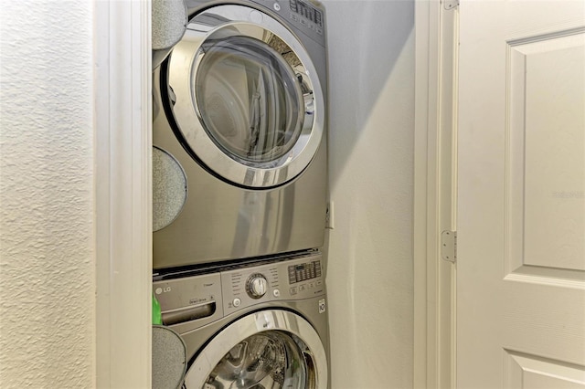 clothes washing area featuring stacked washer / dryer