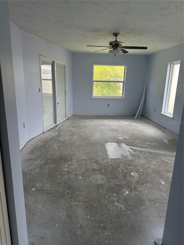 unfurnished room featuring ceiling fan and a textured ceiling