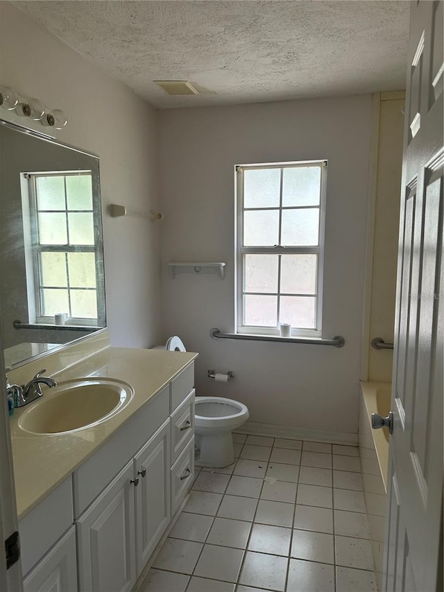 bathroom featuring vanity, tile patterned floors, a textured ceiling, and toilet