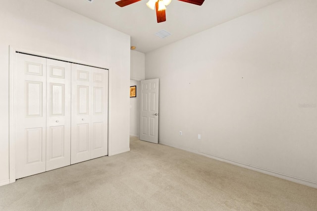 unfurnished bedroom with ceiling fan, a closet, and light colored carpet