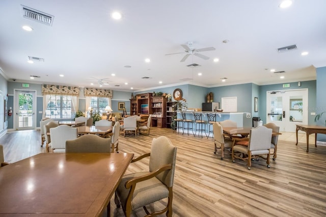 dining area featuring ceiling fan, light wood-type flooring, and ornamental molding