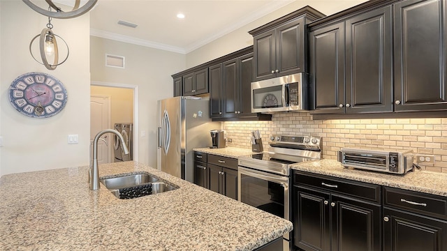 kitchen featuring sink, crown molding, decorative backsplash, light stone counters, and stainless steel appliances