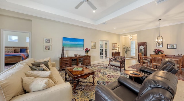 tiled living room featuring ceiling fan with notable chandelier, a raised ceiling, crown molding, and a wealth of natural light