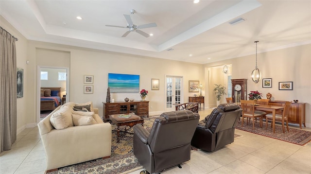 living room featuring ceiling fan, light tile patterned flooring, and a raised ceiling