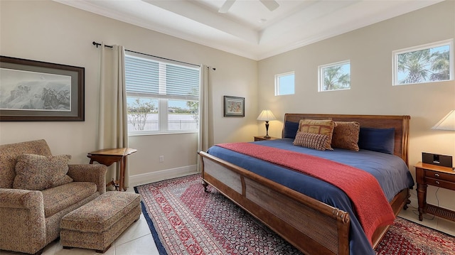 tiled bedroom with a tray ceiling and ceiling fan