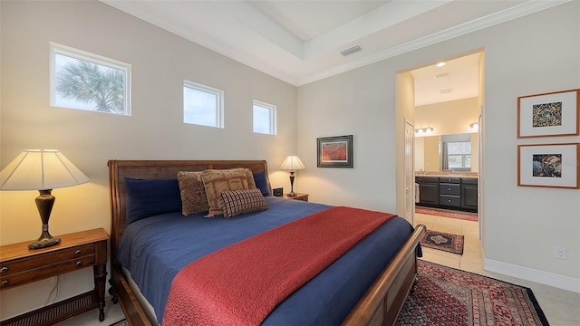 bedroom featuring connected bathroom, a tray ceiling, and light tile patterned flooring