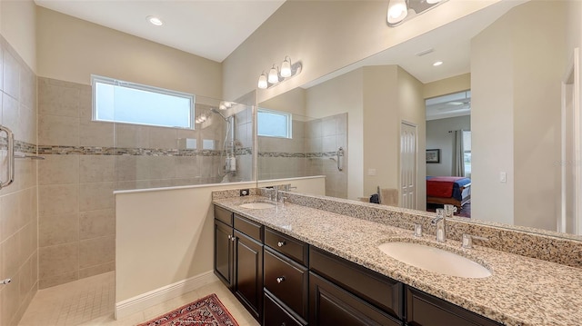 bathroom featuring a tile shower, vanity, and tile patterned floors