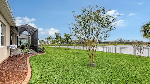 view of yard with a water view and glass enclosure