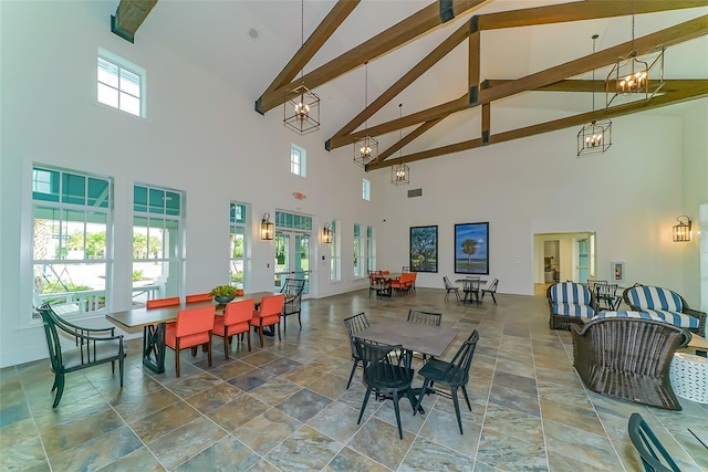 dining room with beamed ceiling and a high ceiling