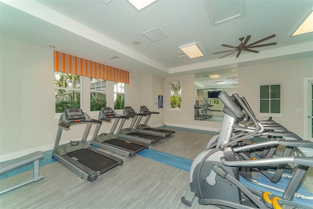 gym with ceiling fan and light hardwood / wood-style flooring