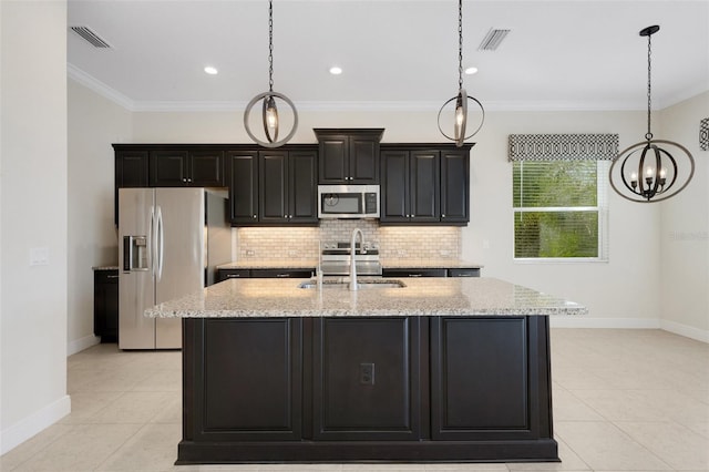 13789 Old Creek Ct, Parrish, FL 34219 - kitchen with appliances with stainless steel finishes, a kitchen island with sink, light tile patterned floors, decorative backsplash, and a chandelier