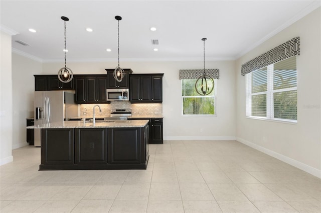 13789 Old Creek Ct, Parrish, FL 34219 - kitchen featuring appliances with stainless steel finishes, backsplash, a center island with sink, ornamental molding, and dark cabinets