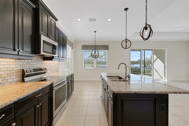 13789 Old Creek Ct, Parrish, FL 34219 - kitchen featuring appliances with stainless steel finishes, backsplash, a center island with sink, light tile patterned flooring, and recessed lighting