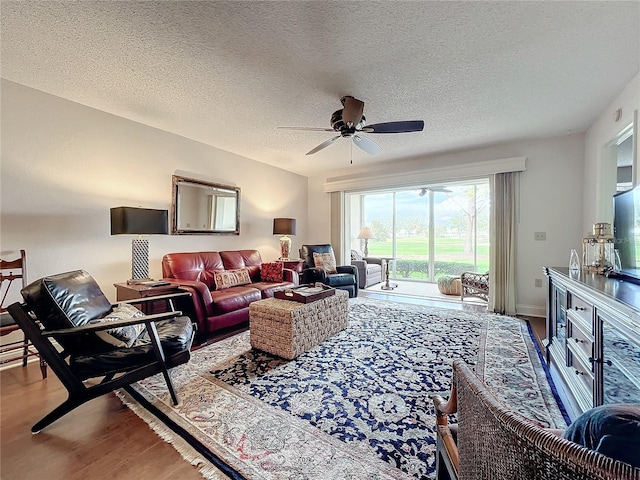 living room with ceiling fan, wood-type flooring, and a textured ceiling