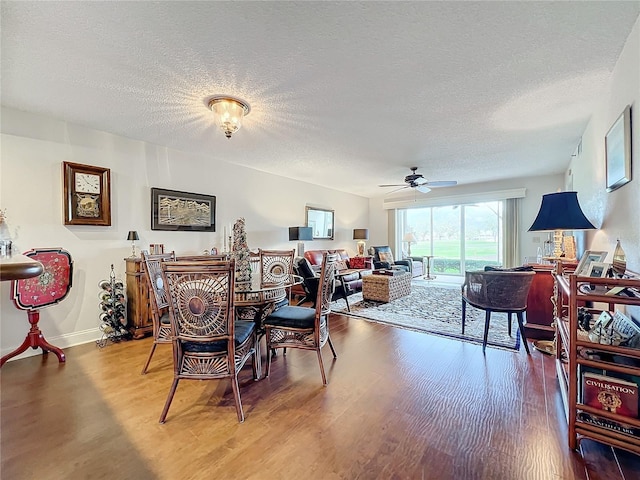 dining area with hardwood / wood-style floors, a textured ceiling, and ceiling fan