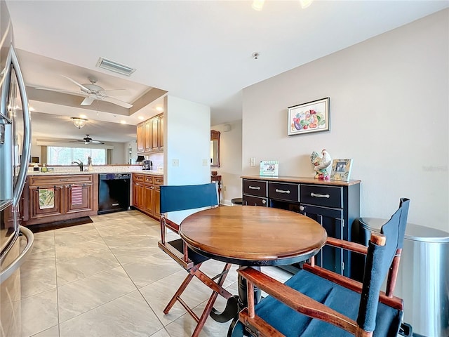 kitchen with kitchen peninsula, stainless steel refrigerator with ice dispenser, ceiling fan, sink, and black dishwasher