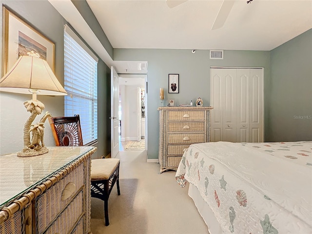 bedroom featuring light colored carpet, a closet, and ceiling fan