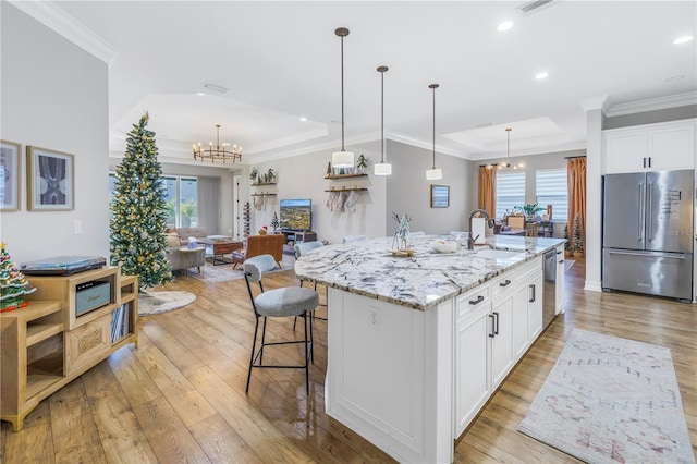 kitchen featuring a healthy amount of sunlight, white cabinetry, an island with sink, and appliances with stainless steel finishes