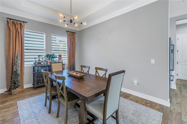 dining area featuring wood-type flooring, crown molding, and a chandelier