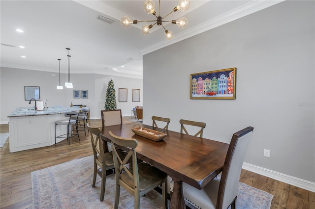 dining room featuring a chandelier, hardwood / wood-style floors, and crown molding