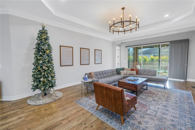 living room with hardwood / wood-style floors, a raised ceiling, and ornamental molding