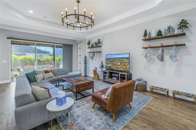 living room featuring a tray ceiling, hardwood / wood-style flooring, and crown molding