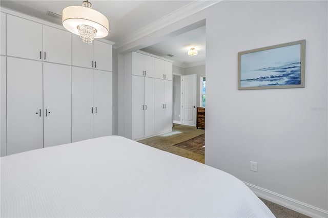 carpeted bedroom with crown molding and a closet