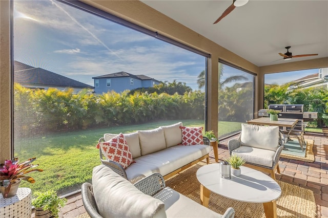 sunroom / solarium featuring ceiling fan